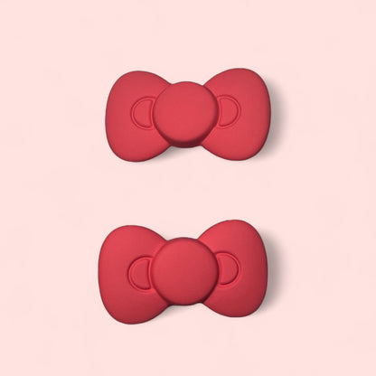 Set of two red silicone hair clips featuring cute bow design, perfect for stylish hairstyles.